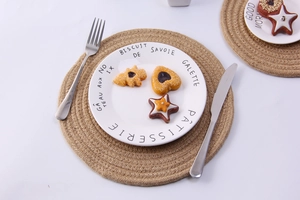 Macro detail of two round natural jute placemats in different sizes on white surface