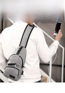 Close-up of gray chest bag with USB charging port and multiple zipper pockets