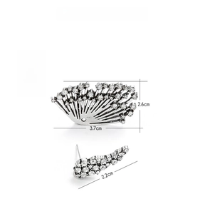 Detailed view of silver alloy asymmetrical wing earrings with crystal rhinestones