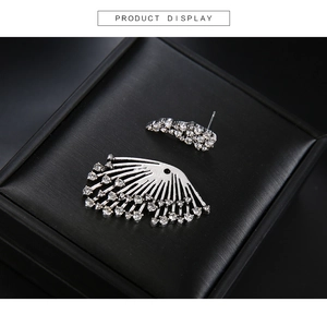 Close-up of asymmetric silver rhinestone earrings displayed in a black jewelry gift box