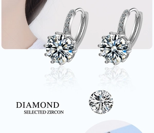 Detail showing round cut zircon with eight-prong setting on silver huggie earrings