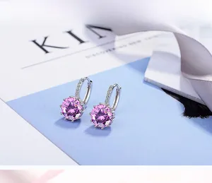 Detail of silver hoop earrings featuring a round purple zircon and pave-set white crystals
