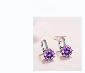 Detail of silver hoop earrings with large purple gemstone and white zircon accents