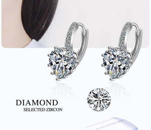Close-up of heart-shaped zircon earrings with six-prong setting and pavé crystals