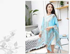 Detail of light blue sun-protective shawl with vintage paisley print and bead accents