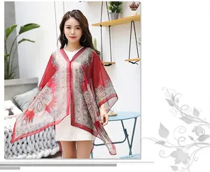 Detail of red paisley chiffon sun protection shawl with elegant pearl button closure