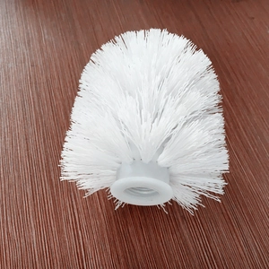 Dettaglio della testa dello scopino bianco con setole in plastica su fondo legno