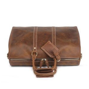 Vintage brown crazy horse leather travel bag with dual handles and luggage tag