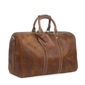 Large brown crazy horse leather travel duffel bag with white stitching and luggage tag