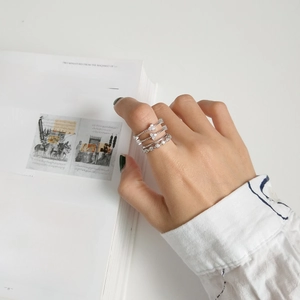 Detail of four-piece silver stacking ring set with heart-shaped zircons on fingers