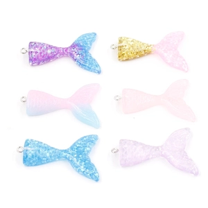 Macro shot of glittery resin mermaid tail charms for DIY jewelry making in various colors