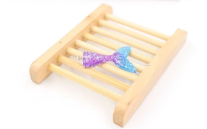 Macro view of gradient purple and blue resin mermaid tail pendant with glitter textures