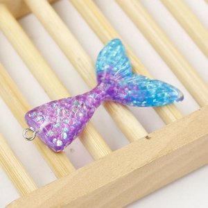 Detailed view of resin mermaid tail pendant with purple to blue gradient and sequins
