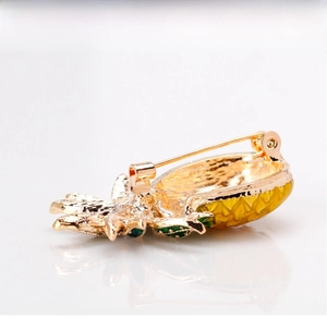 Detailed back view of pineapple brooch showing secure gold pin clasp and metal texture