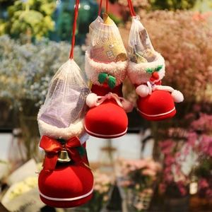 Red flocked Christmas boot candy bags with white mesh nets and golden bells for holiday decor
