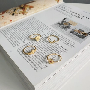 Set of vintage gold bohemian rings featuring moon and star motifs on an open book