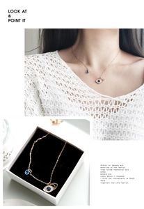 Detail of rose gold evil eye necklace with blue teardrop pendant on a model and in a box