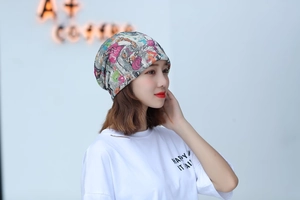 Close-up of printed slouchy beanie with colorful patterns on a soft grey fabric
