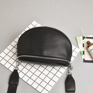 Minimalist black semi-circular crossbody bag with silver hardware and wide adjustable strap