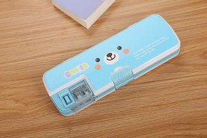 Blue double-layer cartoon pencil box with built-in sharpener on a wooden desk