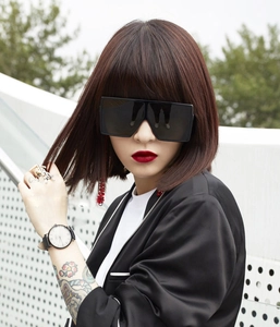 Outdoor model shot of oversized square black sunglasses in a hip-hop fashion style