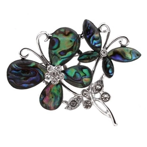Macro detail of butterfly brooch with iridescent abalone shell wings and crystal inlays