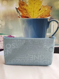 Detail of light blue letter jacquard fabric and metal zipper on the square cosmetic bag