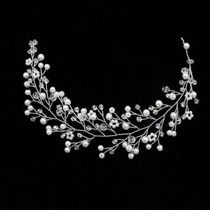 Détail du bandeau de mariée argenté avec perles et cristaux sur fond noir uni