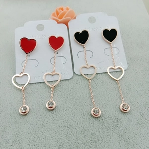 Détail de boucles d'oreilles double cœur en rouge et noir avec accents de zircon