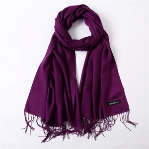 Detail of dark purple cashmere scarf with soft fringe texture and elegant woven finish