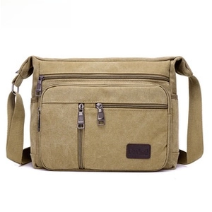 Detail of khaki oxford waist bag showing multi-layer zippers and durable fabric texture