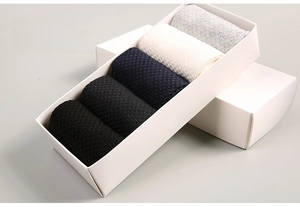 Detail view of five pairs of bamboo fiber socks in black and grey in a minimalist box