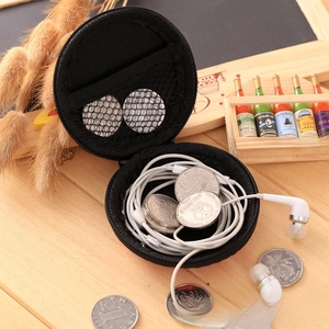 Internal view of round black EVA case showing mesh pocket for earphones and coins