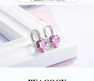 Macro shot of silver heart hoop earrings with pink zircons and small accent stones