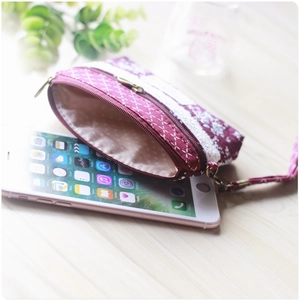 Floral plaid purple fabric coin purse with zipper and wristlet on wooden desk