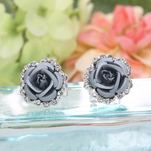 Macro shot of matte gray rose earrings featuring a rhinestone border and silver base