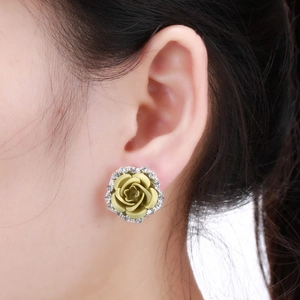 Close-up of rose flower earrings with pale yellow matte petals and sparkling crystals