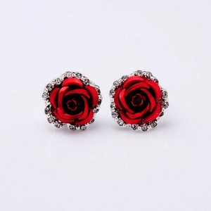 Close-up of red rose earrings with silver diamond-encrusted petals on white background