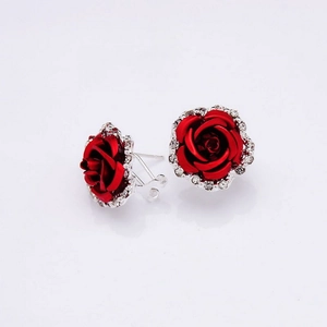 Detail of red rose stud earrings with silver base and sparkling clear rhinestones