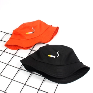 Black and orange bucket hats with cigarette embroidery on a black wire rack