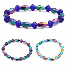 Detailed macro view showing three colorful magnetic hematite beaded bracelets with cross pendants