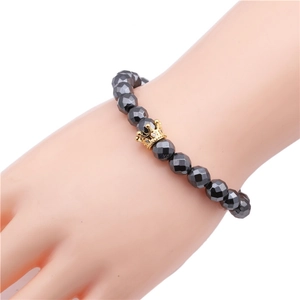 Detail of 8mm faceted magnetic hematite bracelet with gold micro-pave zircon crown charm