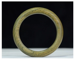 Detalle de brazalete de sándalo verde que muestra la fina textura de la veta de la madera