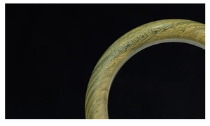 Primer plano de pulsera de sándalo con texturas detalladas de vetas amarillas