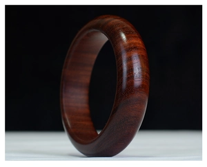 Primer plano macro de la pulsera de sándalo pulido que muestra las vetas naturales de madera