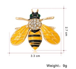 Macro shot of a rhinestone bee brooch showing dimensions 2.7 cm by 3.3 cm and 9g weight