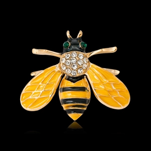 Sparkling bee brooch with yellow enamel and clear rhinestones on a black background