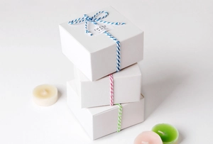 Three-tier white gift boxes decorated with colored cotton ropes and Thank You tags