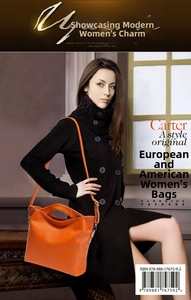 Detail of an orange litchi grain leather handbag with a shoulder strap and metal hardware
