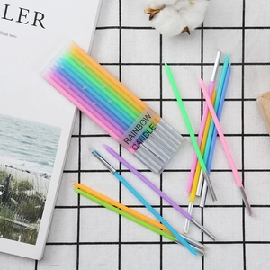 Rainbow thin taper birthday candles set in transparent box on grid background